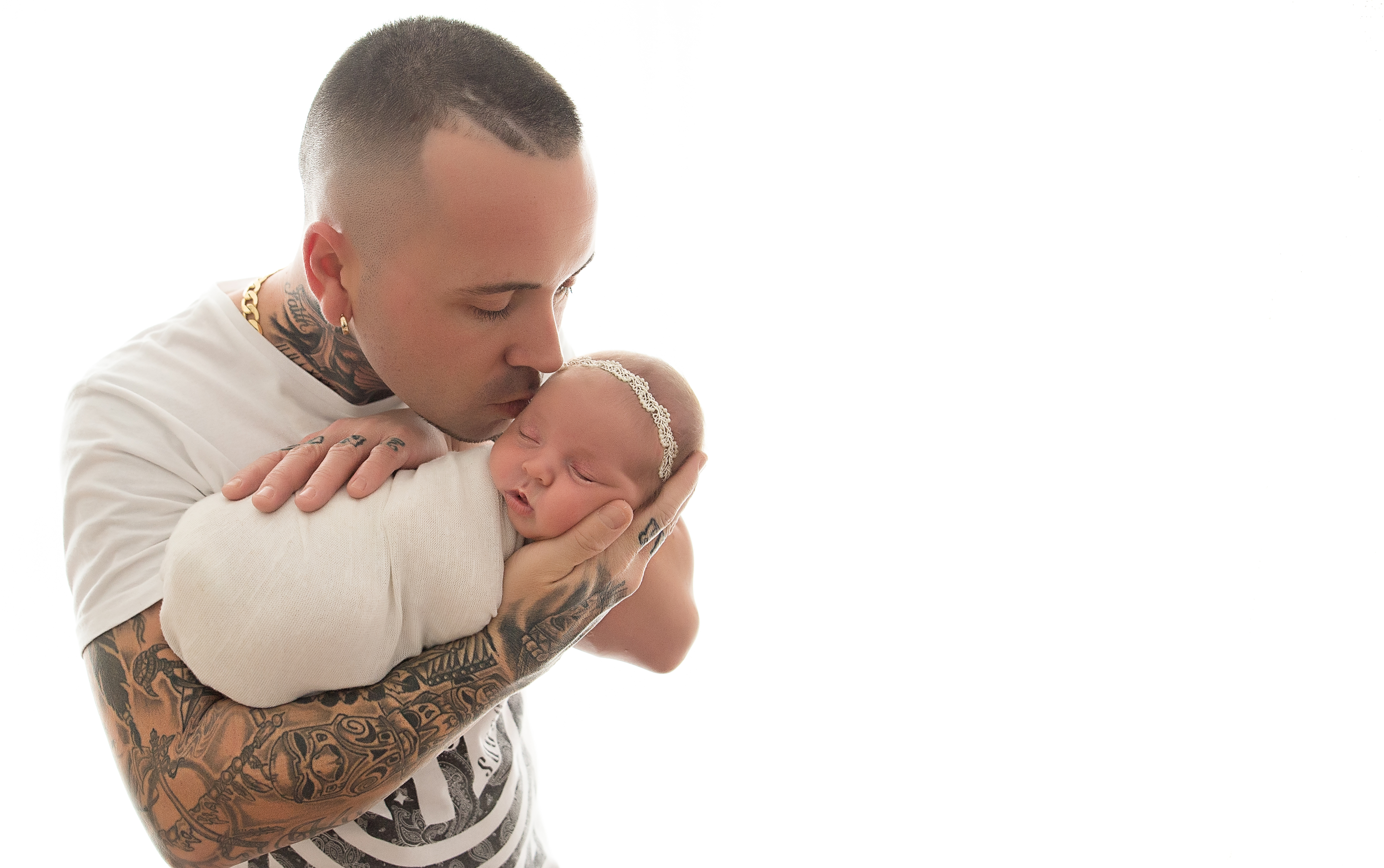 Dad kissing newborn baby