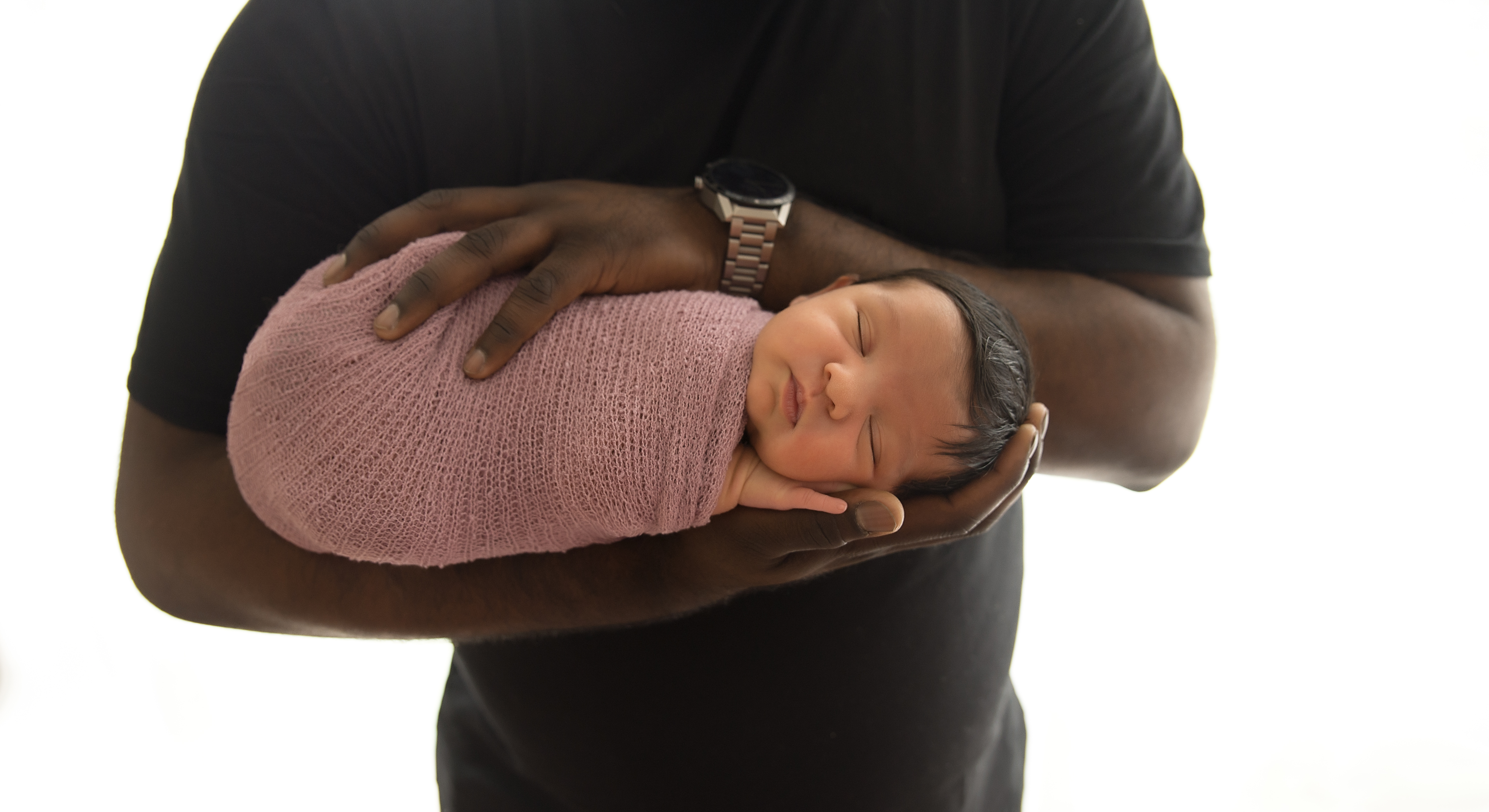 newborn baby in dads arms