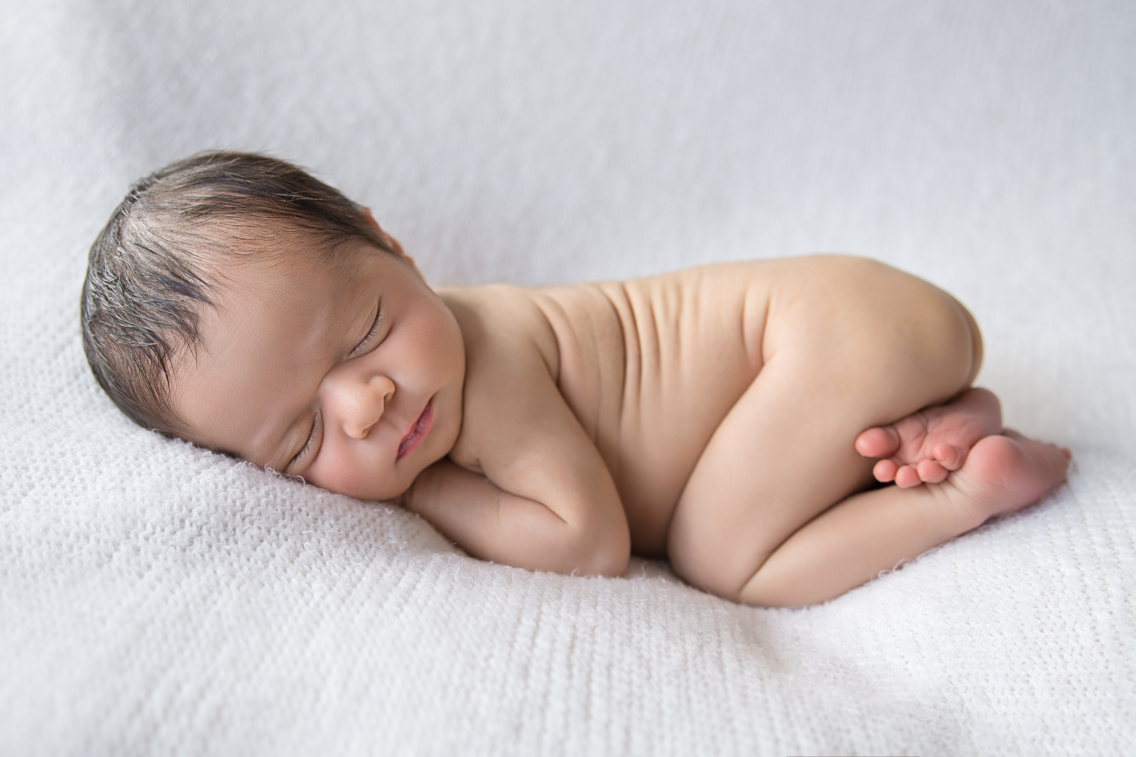 Baby posed need on blanket for newborn photo