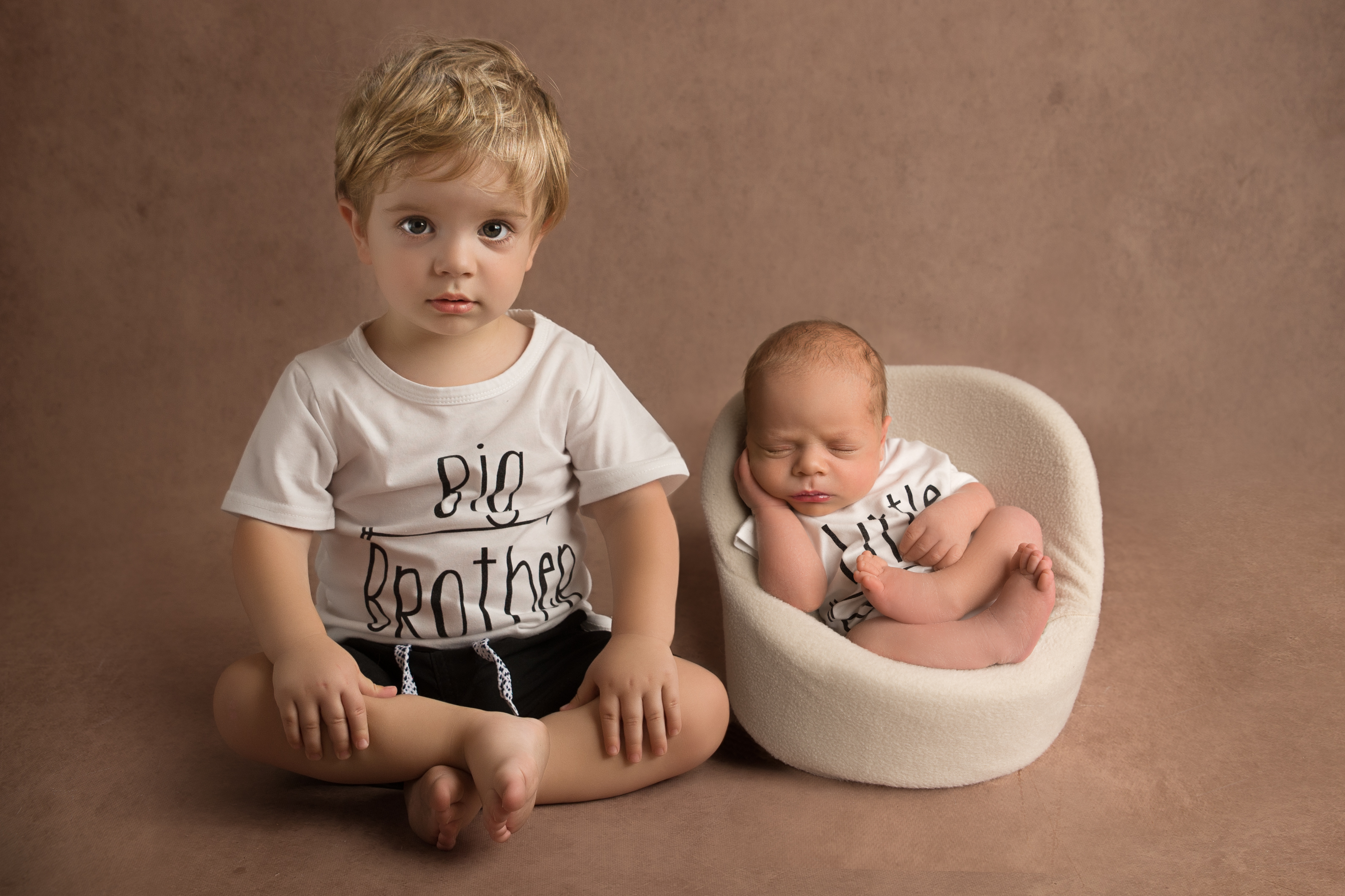 Newborn baby with big brother. Posed together for a photograph