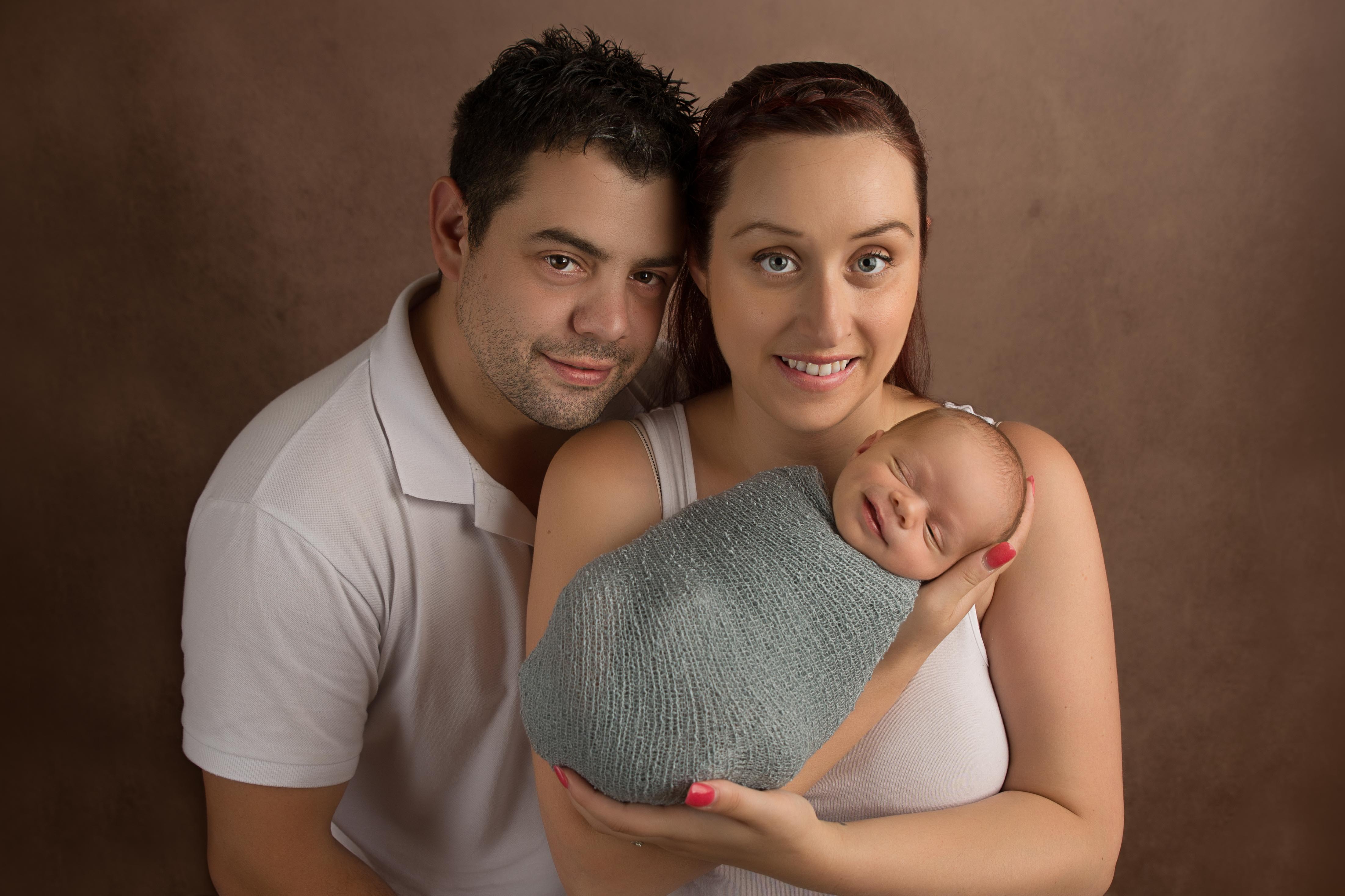 Newborn baby smiling in family photo