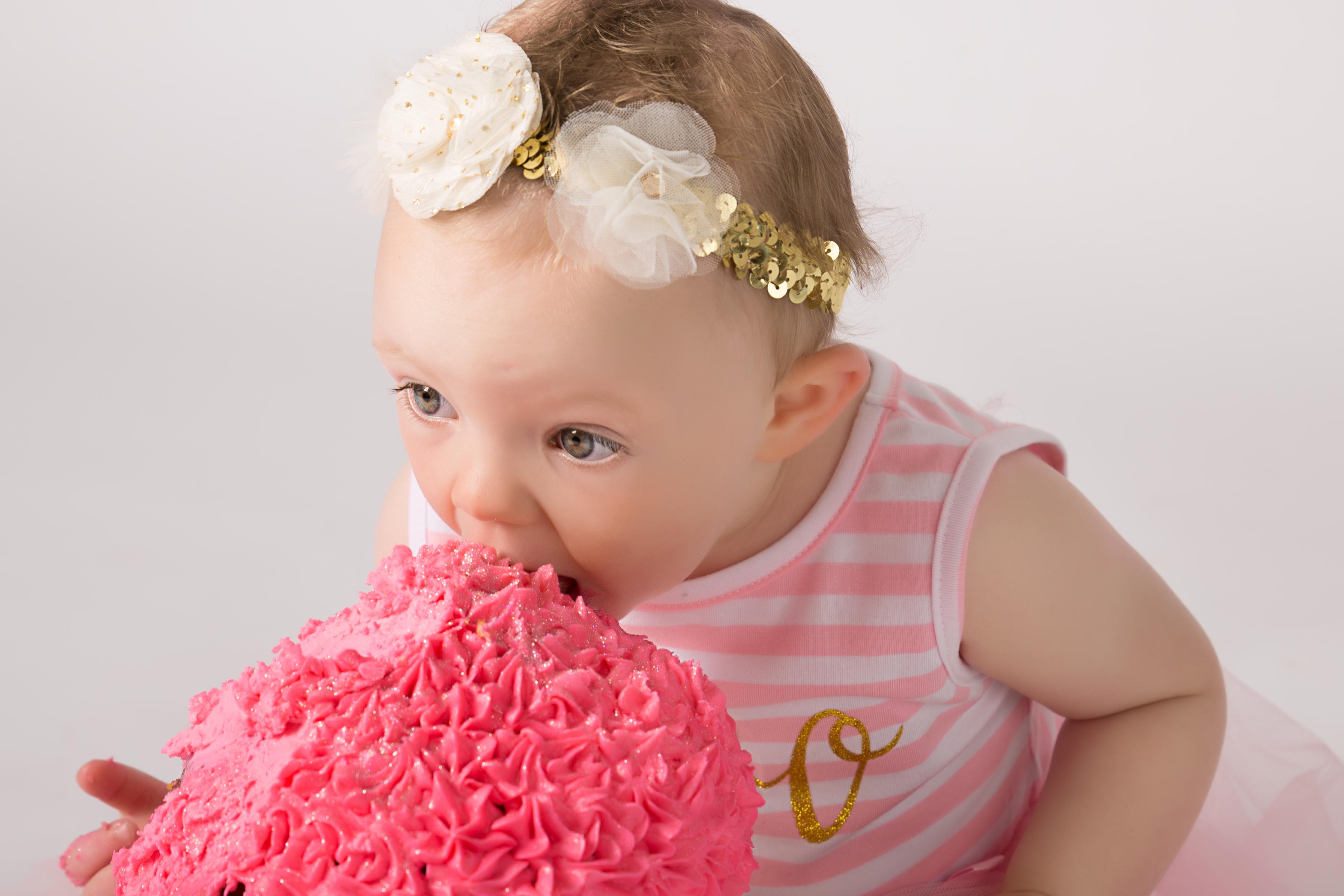 Huge bite into cake for first birthday photoshoot