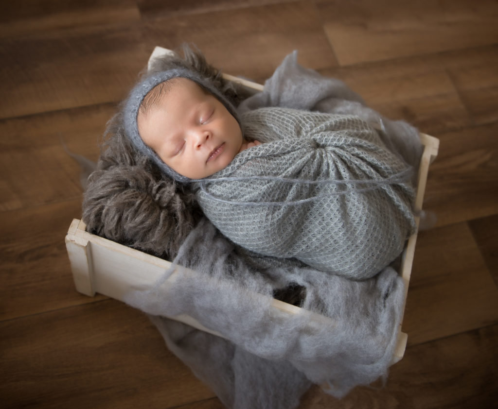 newborn baby wrapped in a box for newborn photography