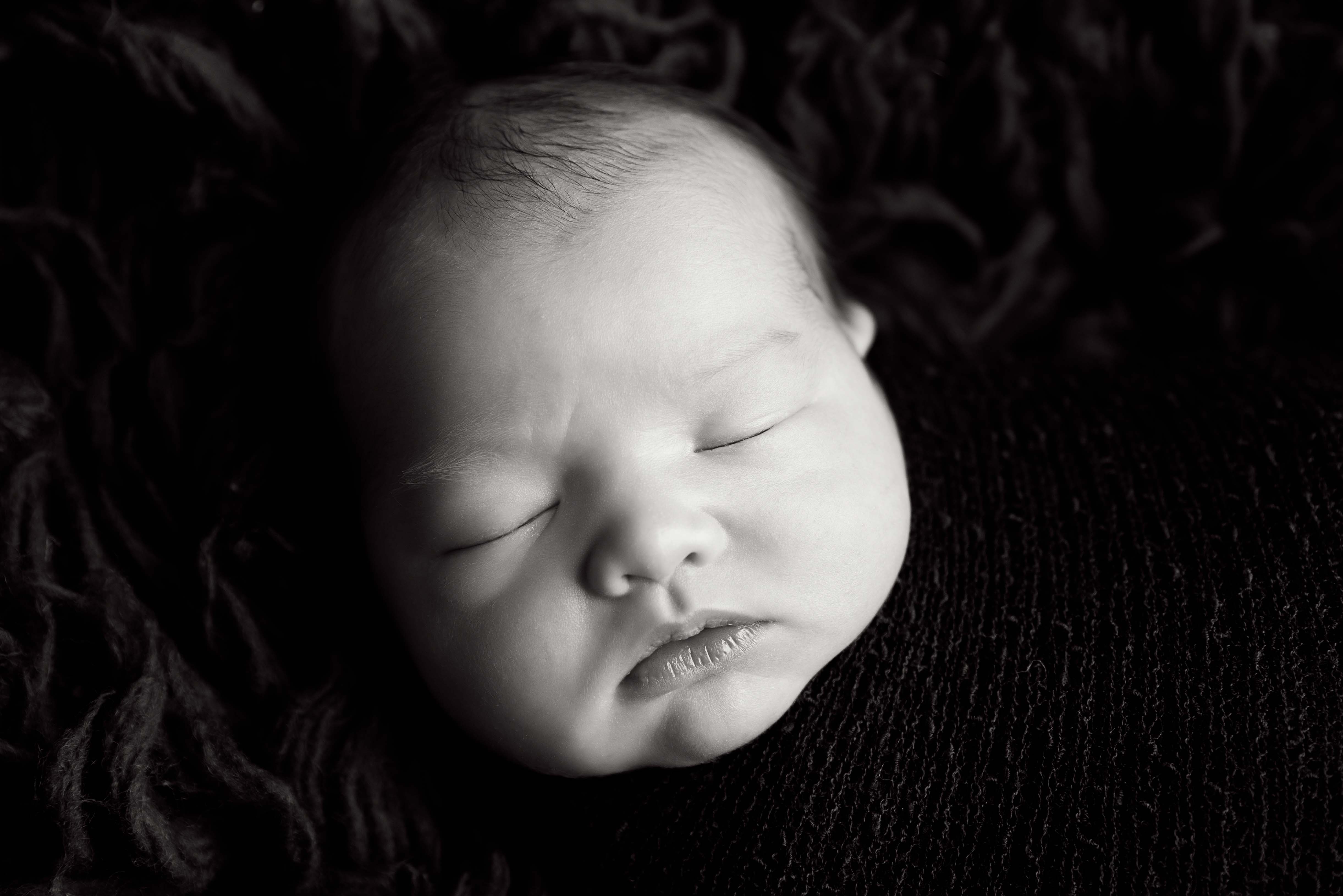 Close up image of newborn baby. Black and white photograph.