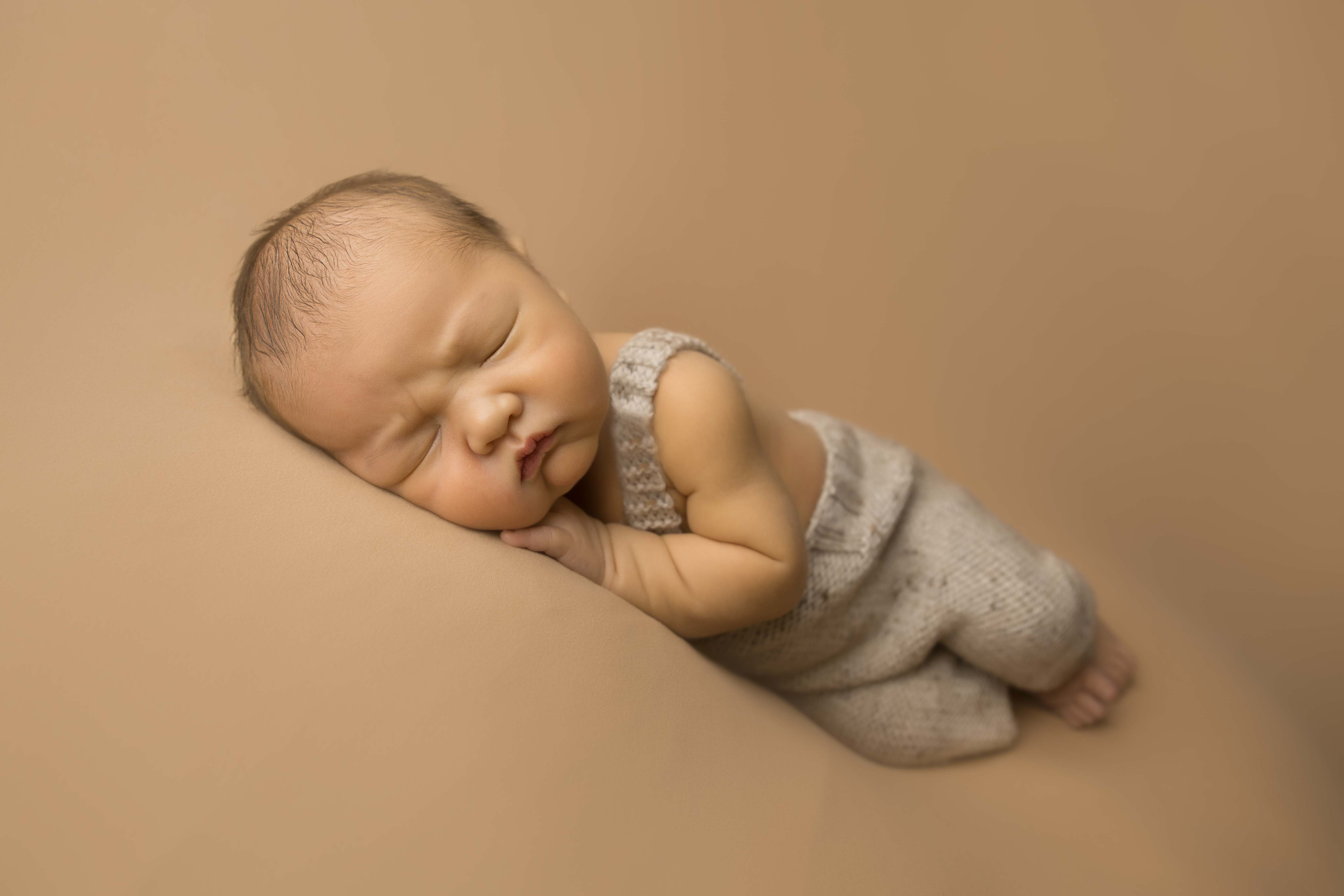 Newborn baby in little farmer overalls. 