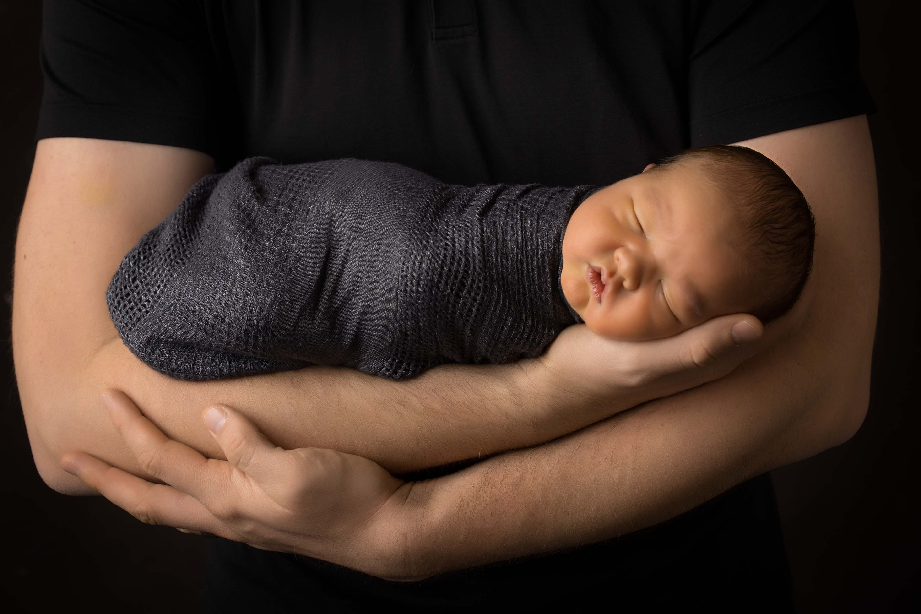 Baby in dads arms.