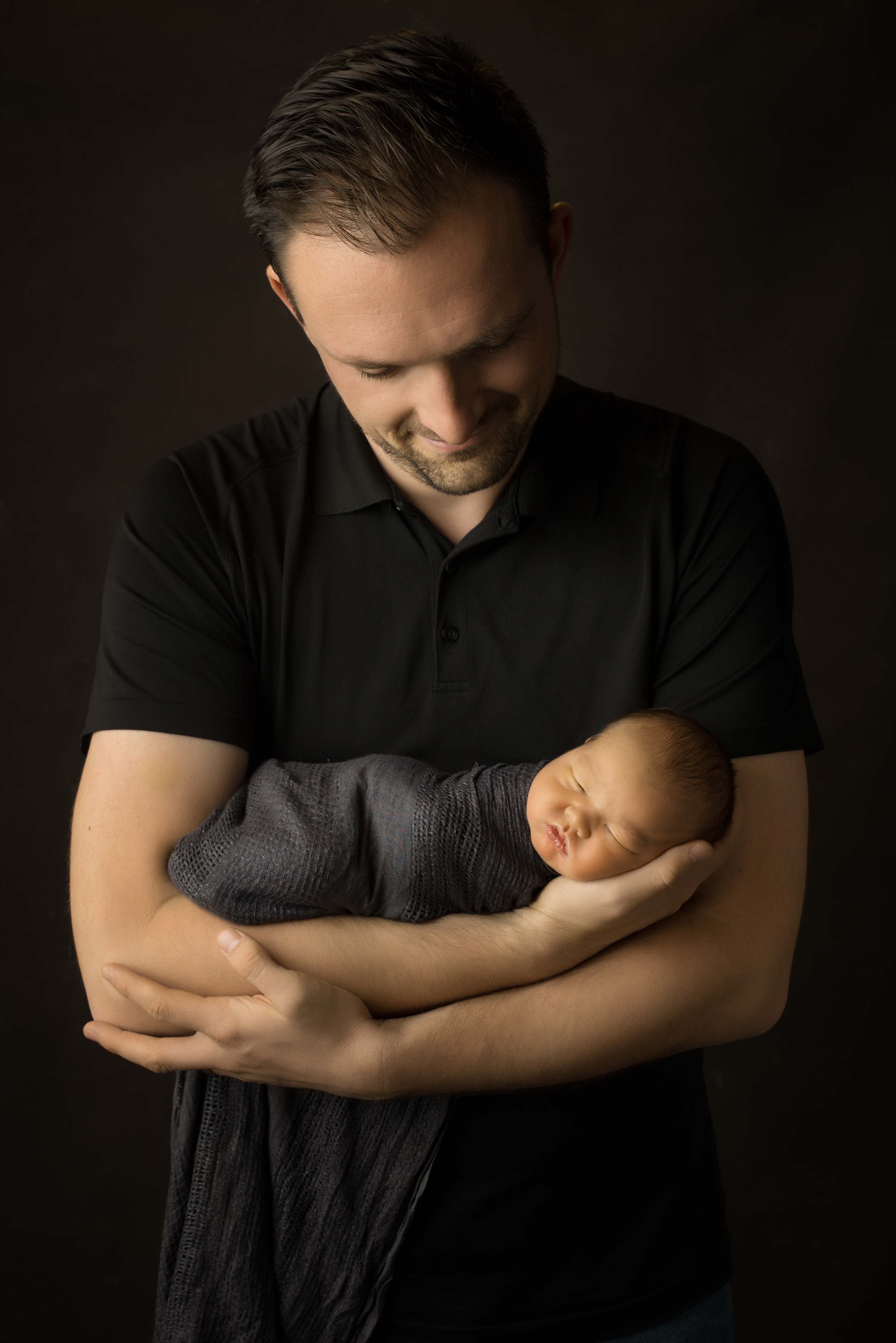 Dad holding baby in his arms. 