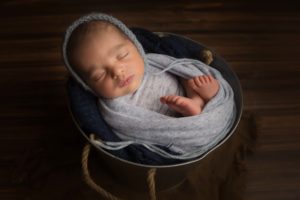 Baby in bucket for newborn photography.