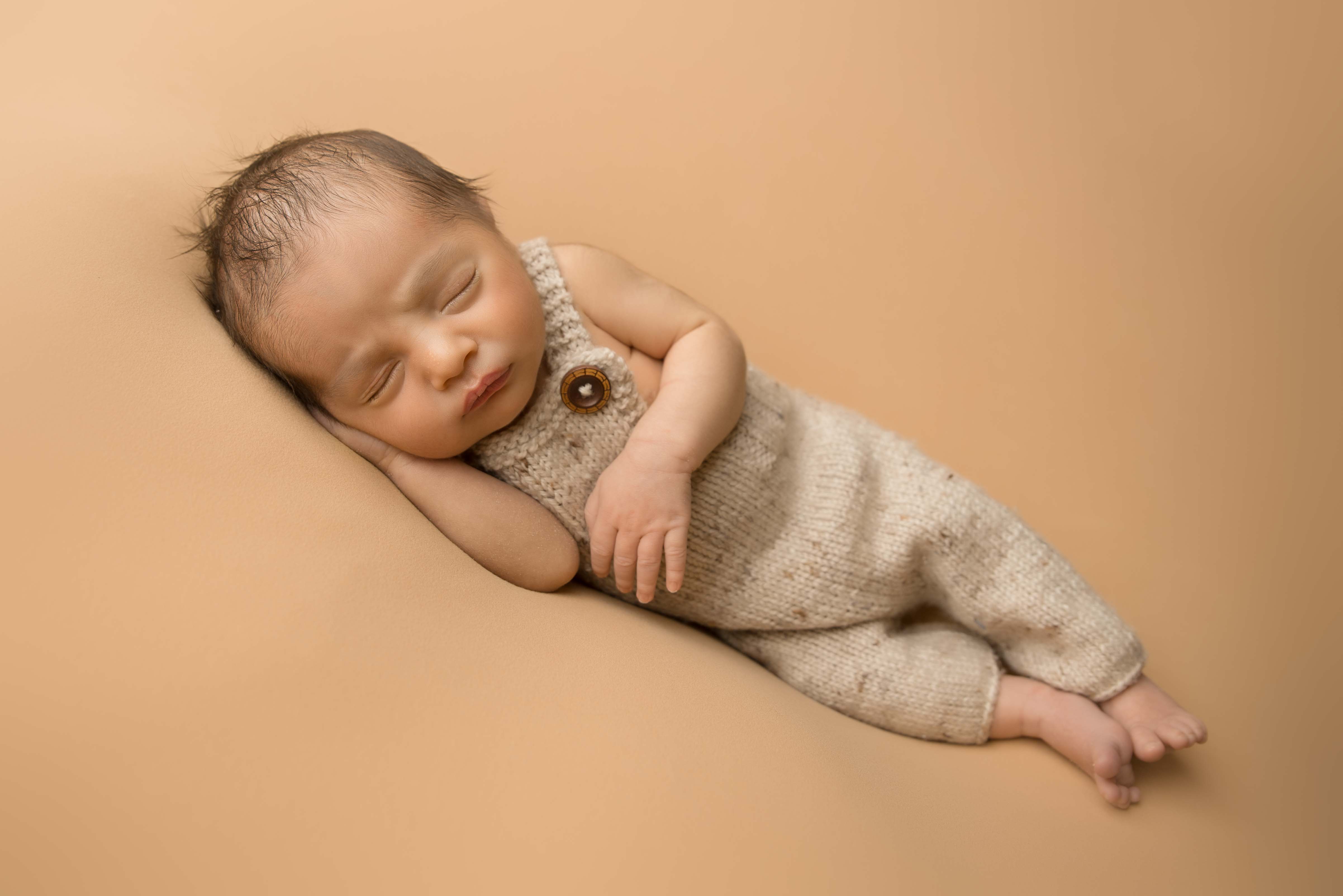 Newborn baby in farmers overalls.