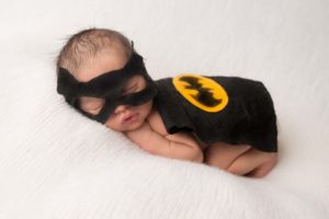 Newborn baby in batman outfit.