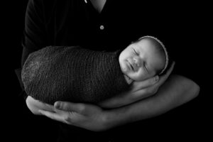 Newborn smiling in dads arms for newborn photographer Melbourne