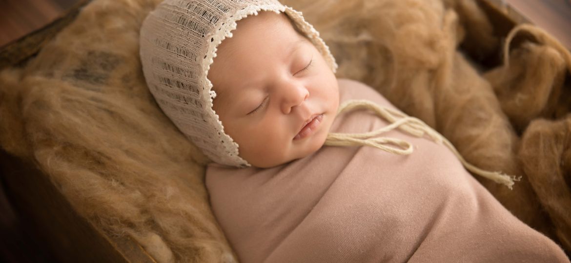 Newborn baby in box with neutral tones