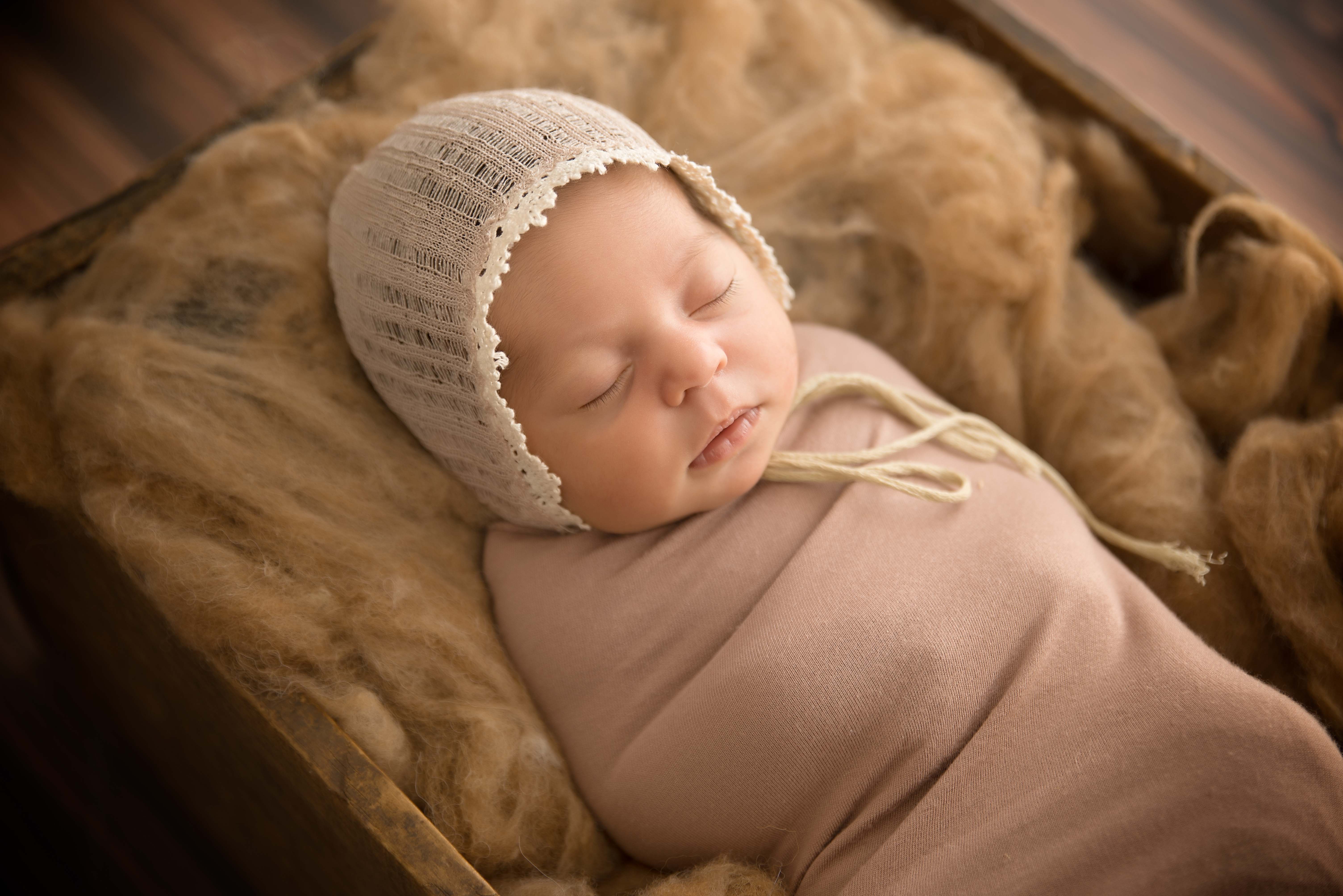 Newborn baby in box with neutral tones