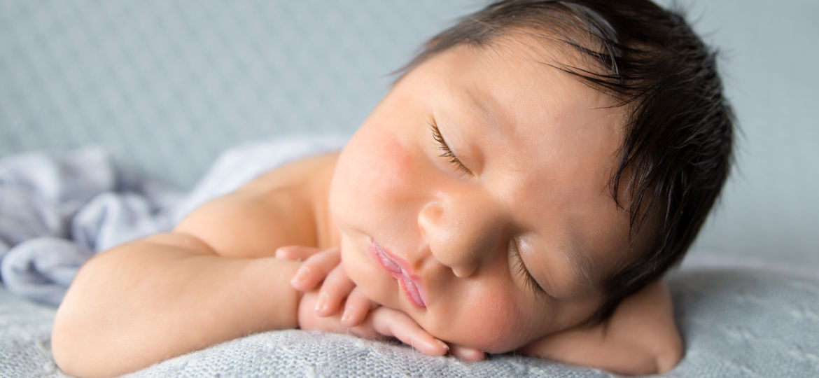 Newborn baby posting on hands for photography