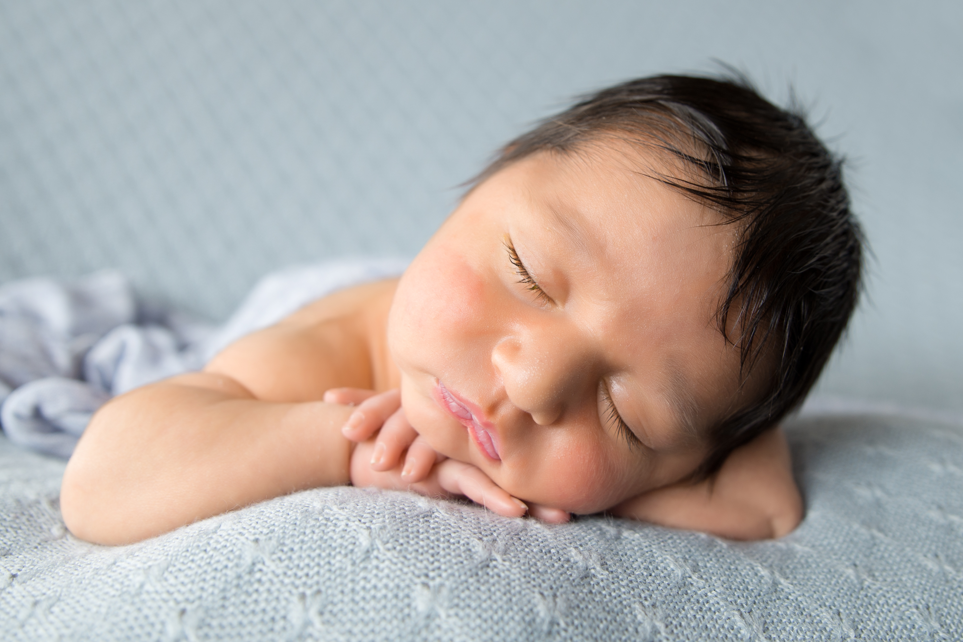 Newborn baby posting on hands for photography