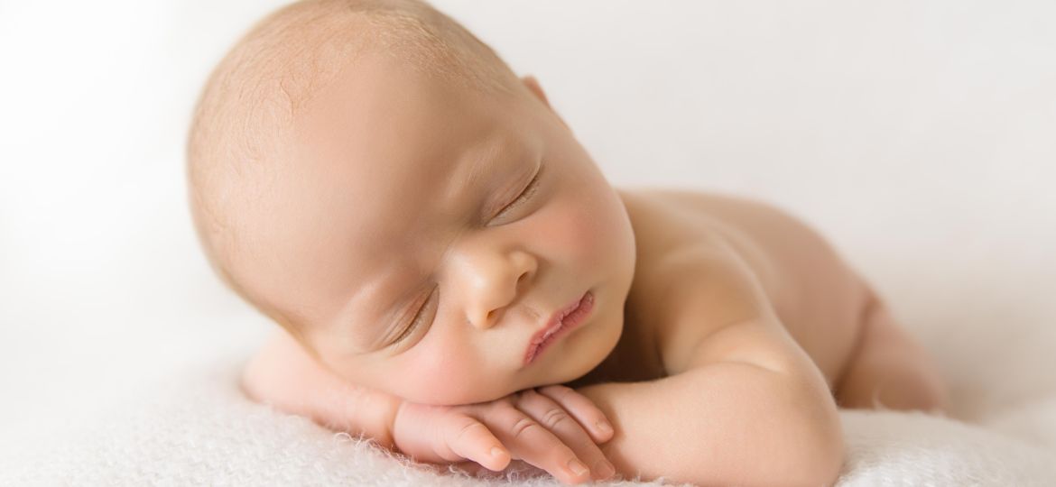 Baby with head on hands and to side