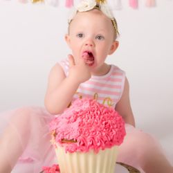 Licking finger with icing on it in cake smash photo