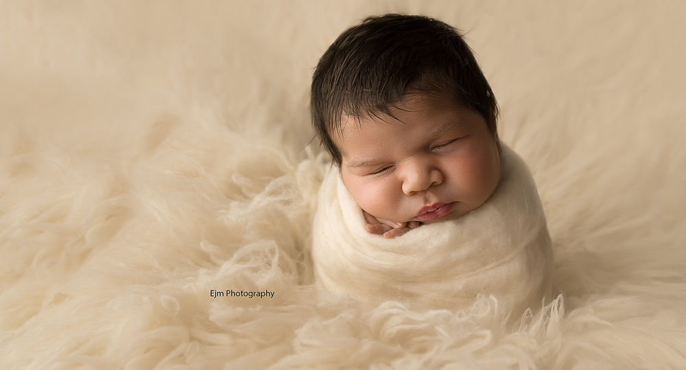 baby wrapped up in fluff in potato sack pose