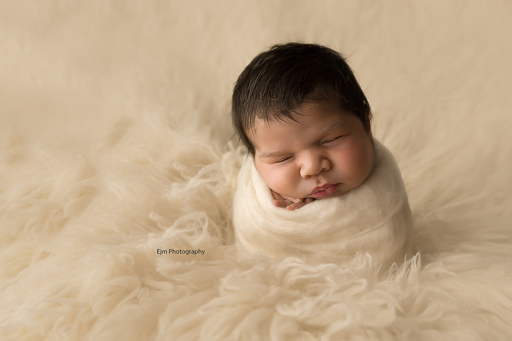 baby wrapped up in fluff in potato sack pose