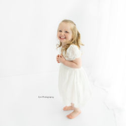 3 year old girl in all white photography set up.