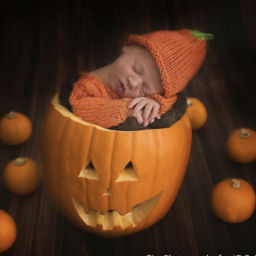 Newborn baby in pumpkin for Halloween