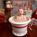 baby in a hot chocolate prop for Christmas photo